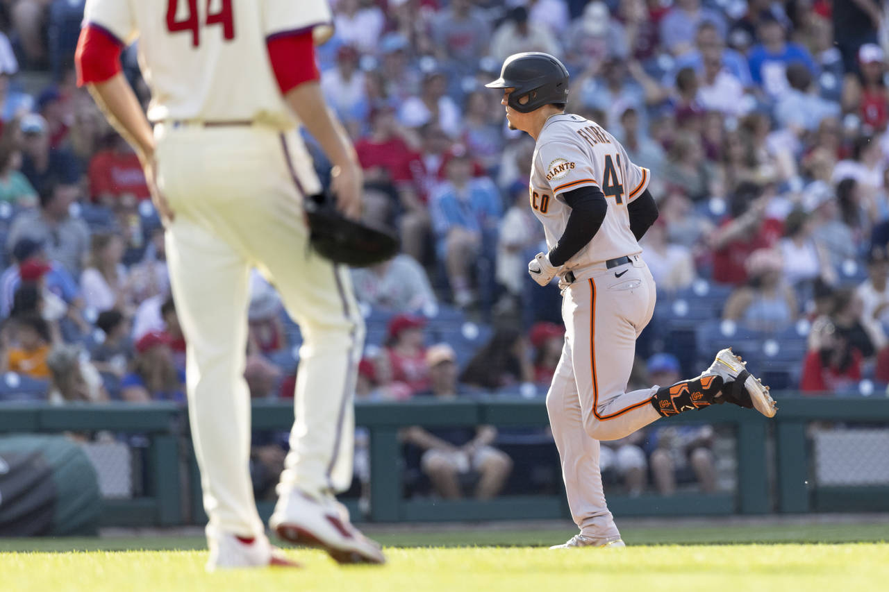 San Francisco Giants' Wilmer Flores, right, runs the bases past Philadelphia Phillies starting pitc...