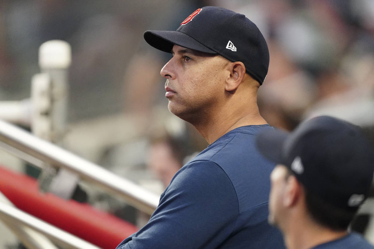 Boston Red Sox manager Alex Cora (13) looks on from the dugout during a baseball game against the A...