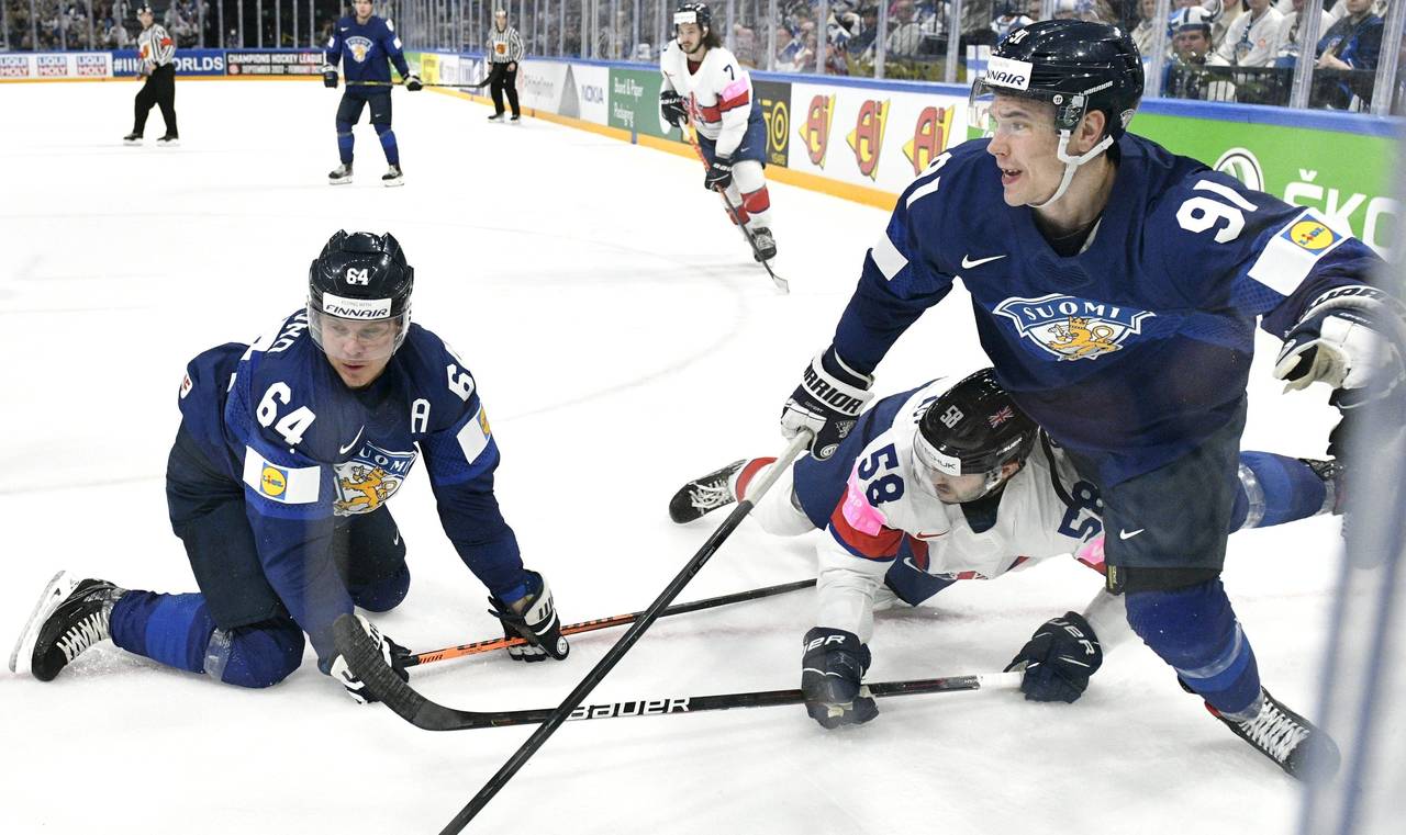 Finland's Mikael Granlund, left, and Juho Lammikko challenge Britain's David Clements during the gr...