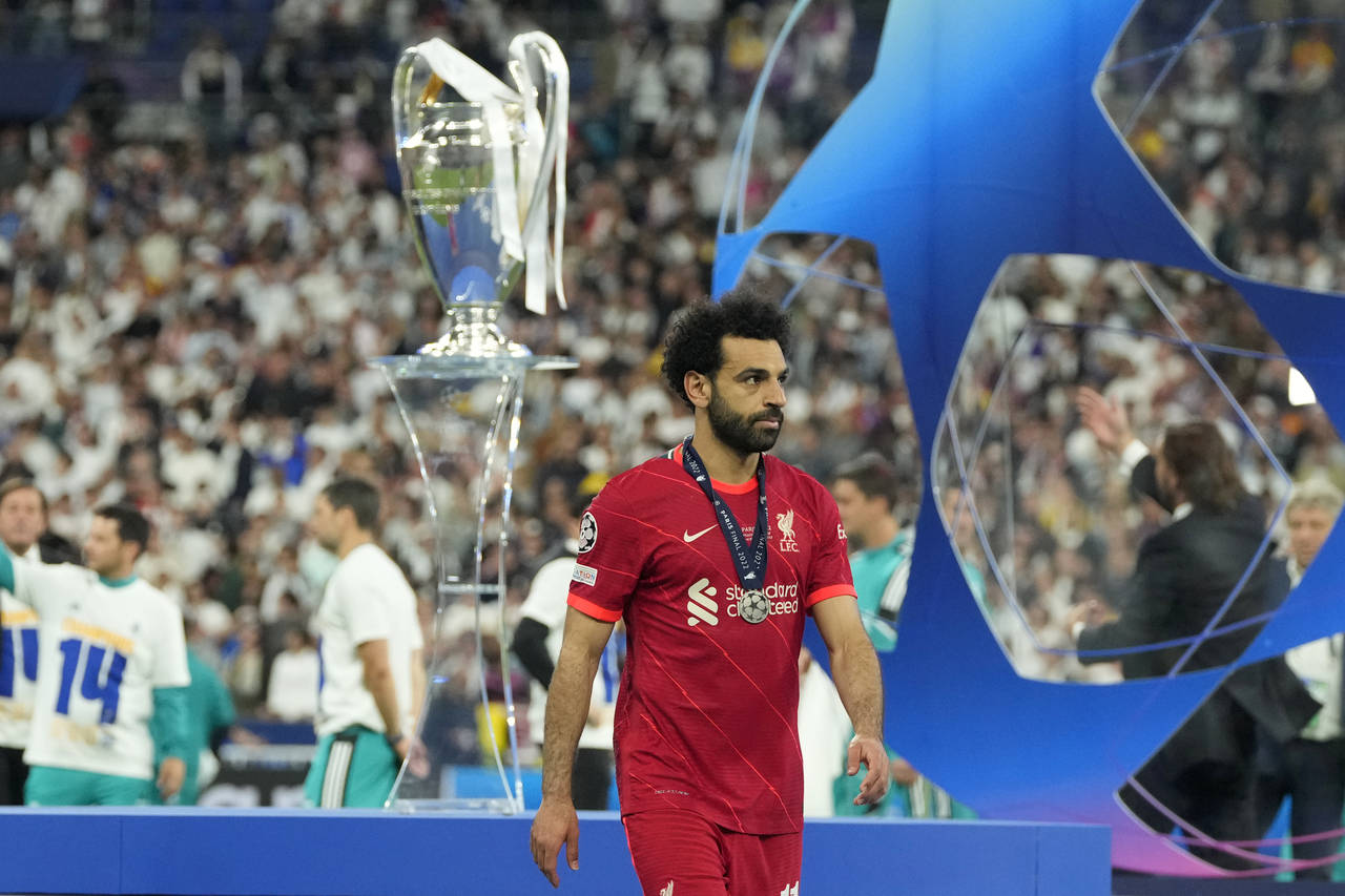 Liverpool's Mohamed Salah, wearing his second place medal. walks past the trophy after the Champion...