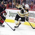 
              Boston Bruins' Brad Marchand (63) controls the puck as Carolina Hurricanes' Jaccob Slavin (74) skates in during the first period of Game 7 of an NHL hockey Stanley Cup first-round playoff series in Raleigh, N.C., Saturday, May 14, 2022. (AP Photo/Karl B DeBlaker)
            