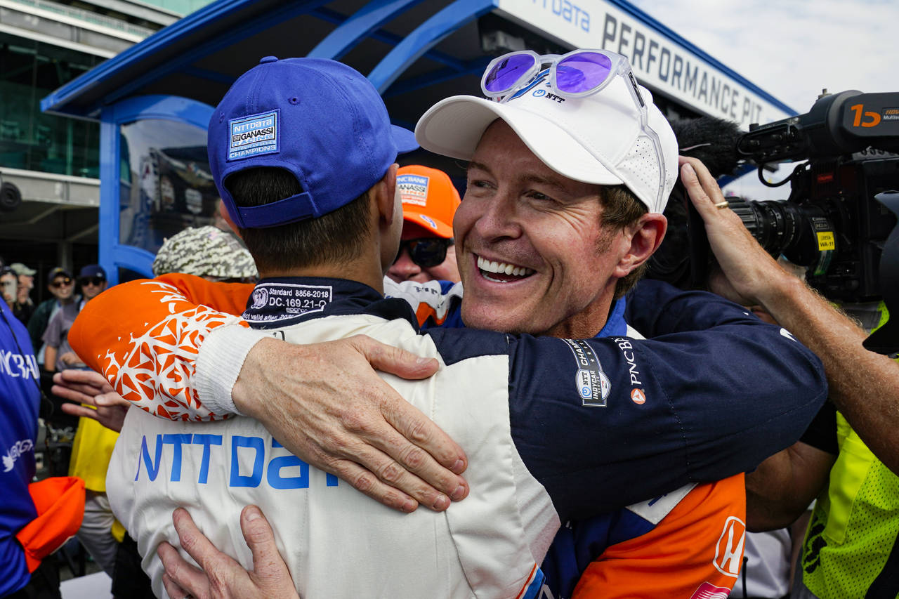 Scott Dixon, of New Zealand, right, celebrates winning the pole with second place finisher Alex Pal...