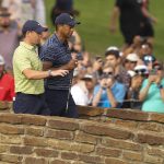 
              Tiger Woods and Rory McIlroy, left, of Northern Ireland, walk on the 13th hole during the first round of the PGA Championship golf tournament, Thursday, May 19, 2022, in Tulsa, Okla. (AP Photo/Matt York)
            