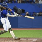 
              Toronto Blue Jays' Bo Bichette hits an RBI double against the Cincinnati Reds during the fifth inning of a baseball game Friday, May 20, 2022, in Toronto. (Jon Blacker/The Canadian Press via AP)
            