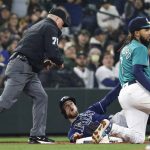 
              Tampa Bay Rays' Brandon Lowe is called out by third base umpire Mike Muchlinski as Seattle Mariners shortstop J.P. Crawford holds up his glove in the fifth inning of a baseball game, Friday, May 6, 2022, in Seattle. (AP Photo/Jason Redmond)
            