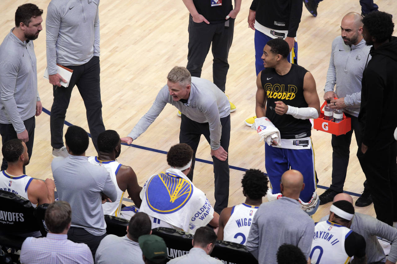 Golden State Warriors coach Steve Kerr talks to the team as a flagrant-2 foul is reviewed during th...