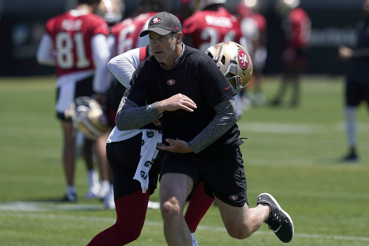 San Francisco 49ers quarterbacks coach Brian Griese, foreground, runs a drill with quarterback Trey...