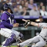
              Colorado Rockies catcher Elias Diaz, left, fields the throw as San Francisco Giants' Mike Yastrzemski slides safely into home plate to score on a double hit by Darin Ruf in the fourth inning of a baseball game Tuesday, May 17, 2022, in Denver. (AP Photo/David Zalubowski)
            