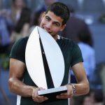 
              FILE - Carlos Alcaraz, of Spain, bites the trophy after winning the final match against Alexander Zverev, of Germany, at the Mutua Madrid Open tennis tournament in Madrid, Spain, Sunday, May 8, 2022. Alcaraz is a 19-year-old from Spain who is the talk of tennis right now, in part because he just beat Rafael Nadal and Novak Djokovic in consecutive matches on clay on the way to the Madrid Open title. (AP Photo/Paul White, File)
            