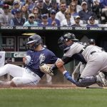 
              Kansas City Royals' Whit Merrifield, left, is tagged out by New York Yankees catcher Kyle Higashioka as he tried to score on a fielder's choice hit by Salvador Perez during the third inning of a baseball game Sunday, May 1, 2022, in Kansas City, Mo. (AP Photo/Charlie Riedel)
            