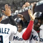 
              Miami Marlins' Jesus Sanchez, right, and Brian Anderson, center, are congratulated after scoring on a home run by Anderson during the fourth inning of the team's baseball game against the Milwaukee Brewers, Saturday, May 14, 2022, in Miami. (AP Photo/Lynne Sladky)
            