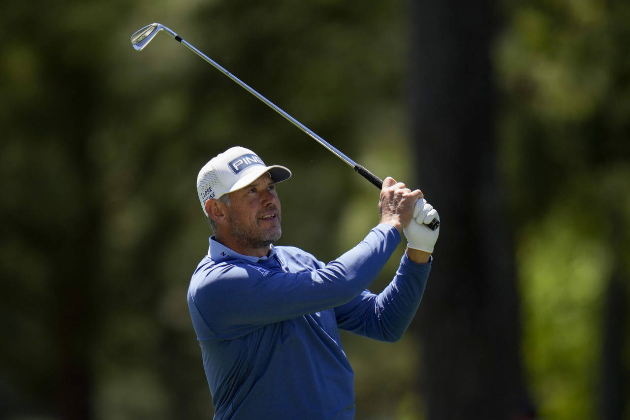 Lee Westwood, of England, watches his shot on the first fairway during the final round at the Maste...
