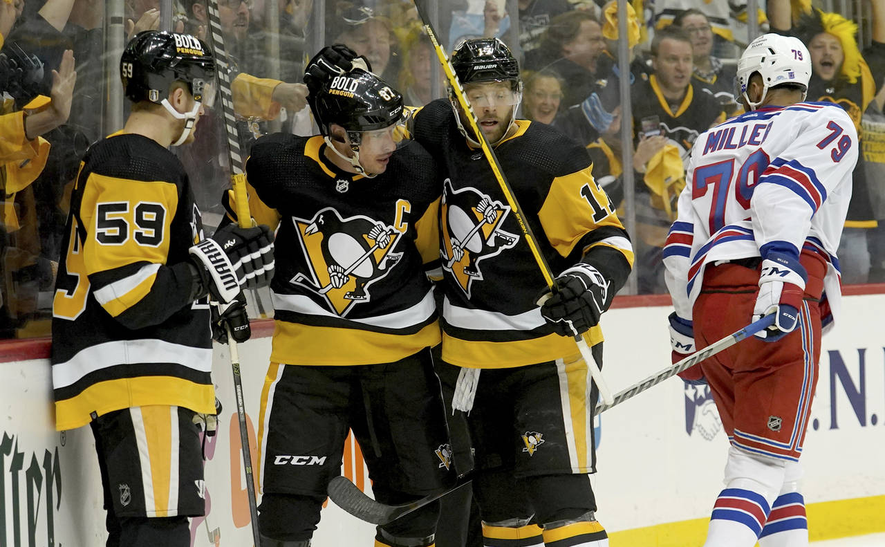 Pittsburgh Penguins left winger Jake Guentzel (59) and right winger Bryan Rust (17) congratulate ce...