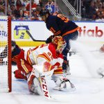 
              Calgary Flames goalie Jacob Markstrom, left, lets in a goal from Edmonton Oilers winger Evander Kane during the second period of an NHL hockey Stanley Cup second-round playoff series game in Edmonton, Alberta, Sunday, May 22, 2022. (Jeff McIntosh/The Canadian Press via AP)
            