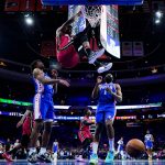 
              Miami Heat's Jimmy Butler hangs from the rim after dunking against Philadelphia 76ers' Tyrese Maxey (0) and James Harden (1) during the second half of Game 6 of an NBA basketball second-round playoff series, Thursday, May 12, 2022, in Philadelphia. (AP Photo/Matt Slocum)
            