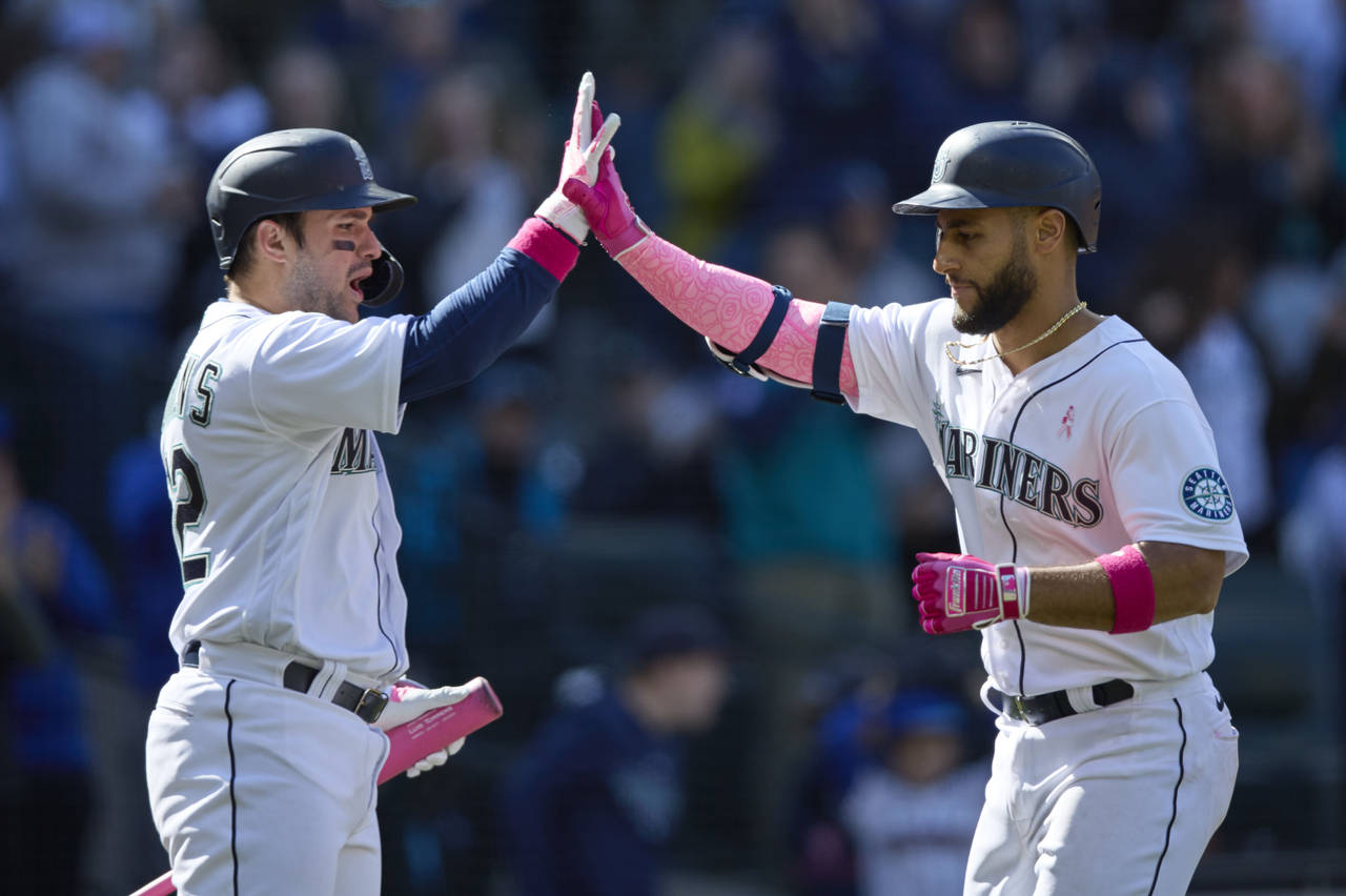Seattle Mariners' Abraham Toro, right, is greeted at home plate by Luis Torrens after hitting a sol...