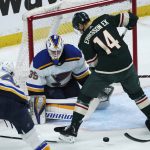 
              St. Louis Blues goalie Ville Husso (35) looks on as Minnesota Wild's Joel Eriksson Ek (14) looks for the puck in the first period of Game 1 of an NHL hockey Stanley Cup first-round playoff series, Monday, May 2, 2022, in St. Paul, Minn. (AP Photo/Jim Mone)
            