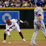 
              Arizona Diamondbacks' Geraldo Perdomo fields the ball after New York Mets' Robinson Cano (24) was hit by a base hit by Jeff McNeil for an out during the seventh inning of a baseball game, Saturday, April 23, 2022, in Phoenix. (AP Photo/Matt York)
            