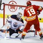 
              Edmonton Oilers goalie Mike Smith, left, deflects a shot wide of the net as Calgary Flames' Matthew Tkachuk looks for a rebound during the second period of Game 5 of an NHL hockey second-round playoff series Thursday, May 26, 2022, in Calgary, Alberta. (Jeff McIntosh/The Canadian Press via AP)
            