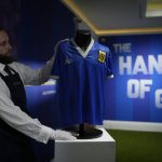 
              FILE - The Argentina football shirt worn by Diego Maradona in the 1986 Mexico World Cup quarterfinal soccer match between Argentina and England, is displayed for photographs at Sotheby's auction house, in London, Wednesday, April 20, 2022. The shirt worn by Maradona when he scored the controversial “Hand of God” goal has sold for 7.1 million pounds ($9.3 million), the highest price ever paid at auction for a piece of sports memorabilia. Auctioneer Sotheby’s sold the shirt in an online auction that closed Wednesday, May 4, 2022. (AP Photo/Matt Dunham, File)
            