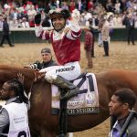 
              Sonny Leon rides Rich Strike to the winner's circle after winning the 148th running of the Kentucky Derby horse race at Churchill Downs Saturday, May 7, 2022, in Louisville, Ky. (AP Photo/Jeff Roberson)
            