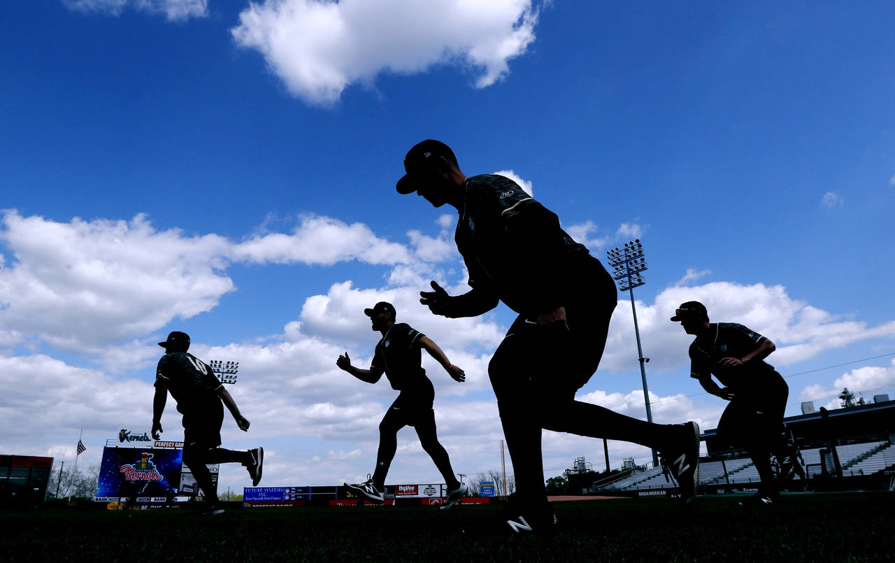 FILE - Quad Cities River Bandits players warm up before a Class-A Midwest League baseball game agai...
