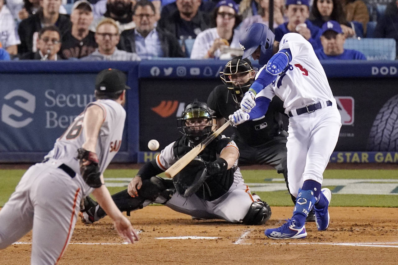 Los Angeles Dodgers' Chris Taylor, right, hits a two RBI single as San Francisco Giants starting pi...