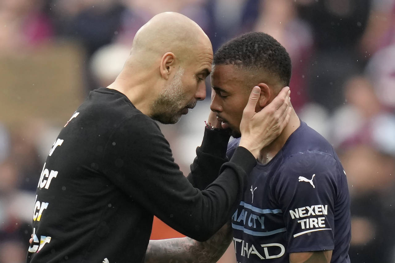 Manchester City's head coach Pep Guardiola, left, interacts with player Gabriel Jesus at the end of...