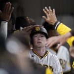 
              San Diego Padres' Jake Cronenworth is greeted in the dugout after scoring off an RBI-double by Manny Machado during the sixth inning of a baseball game against the Chicago Cubs, Tuesday, May 10, 2022, in San Diego. (AP Photo/Gregory Bull)
            