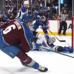 
              St. Louis Blues goaltender Jordan Binnington (50) makes a save against Colorado Avalanche defenseman Erik Johnson (6) during the second period in Game 1 of an NHL hockey Stanley Cup second-round playoff series Tuesday, May 17, 2022, in Denver. (AP Photo/Jack Dempsey)
            
