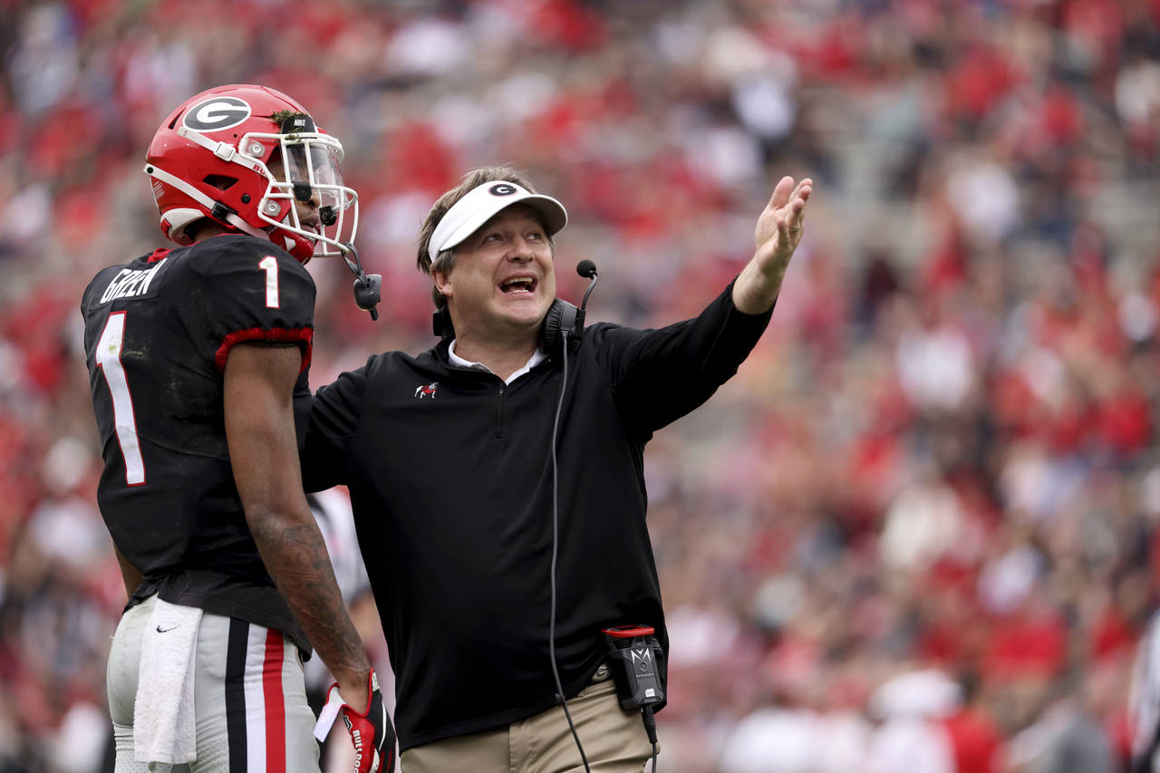 Georgia coach Kirby Smart talks with defensive back Nyland Green (1) after a play during the NCAA c...