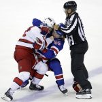 
              Linesman Jonny Murray tries to stop New York Rangers defenseman Ryan Lindgren (55) and Carolina Hurricanes center Max Domi from fighting after Game 3 of an NHL hockey Stanley Cup second-round playoff series, Sunday, May 22, 2022, in New York. (AP Photo/Adam Hunger)
            
