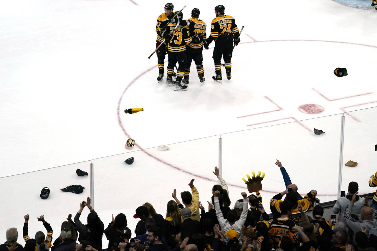 Boston Bruins center Patrice Bergeron (37) celebrates with teammates after scoring the third goal o...