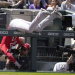 
              Cincinnati Reds third baseman Brandon Drury tumbles over the rail for the third-base well while pursuing a pop foul off the bat of Colorado Rockies' Elias Diaz in the second inning of a baseball game, Sunday, May 1, 2022, in Denver. (AP Photo/David Zalubowski)
            