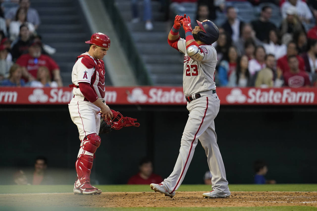 Washington Nationals designated hitter Nelson Cruz (23) points to the sky as he crosses home plate ...