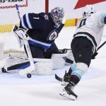 
              Winnipeg Jets' goaltender Eric Comrie (1) makes a save against Seattle Kraken's Ryan Donato (9) during the second period of NHL hockey game action in Winnipeg, Manitoba, Sunday, May 1, 2022. (Fred Greenslade/The Canadian Press via AP)
            
