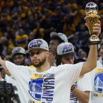 
              Golden State Warriors' Stephen Curry holds up the conference finals MVP trophy after the Warriors defeated the Dallas Mavericks in Game 5 of the NBA basketball playoffs Western Conference finals in San Francisco, Thursday, May 26, 2022. (AP Photo/Jeff Chiu)
            