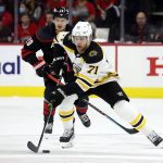 
              Boston Bruins' Taylor Hall (71) moves the puck away from Carolina Hurricanes' Sebastian Aho (20) during the first period of Game 7 of an NHL hockey Stanley Cup first-round playoff series in Raleigh, N.C., Saturday, May 14, 2022. (AP Photo/Karl B DeBlaker)
            