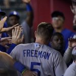 
              Los Angeles Dodgers' Freddie Freeman (5) is greeted in the dugout after scoring on a sacrifice fly hit by teammate Will Smith during the fifth inning of a baseball game against the Arizona Diamondbacks, Saturday, May 28, 2022, in Phoenix.(AP Photo/Matt York)
            