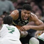 
              Milwaukee Bucks forward Giannis Antetokounmpo, center, grapples with Boston Celtics guard Jaylen Brown (7) during the second half of Game 7 of an NBA basketball Eastern Conference semifinals playoff series, Sunday, May 15, 2022, in Boston. (AP Photo/Steven Senne)
            