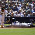 
              Milwaukee Brewers' Luis Urias, right, arrives safely at third, advancing from first on a single by Andrew McCutchen, as San Diego Padres third baseman Manny Machado is late with the tag during the seventh inning of a baseball game Wednesday, May 25, 2022, in San Diego. (AP Photo/Gregory Bull)
            