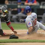 
              Chicago Cubs' Patrick Wisdom (16) slides safely into home plate on a Frank Schwindel single while Chicago White Sox catcher Yasmani Grandal, left, misses the throw during the first inning of a baseball game at Guaranteed Rate Field, Saturday, May 28, 2022, in Chicago. (AP Photo/Paul Beaty)
            