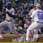 
              Los Angeles Dodgers' Mookie Betts, left, scores on a wild pitch by Chicago Cubs relief pitcher Michael Rucker (59) during the fifth inning of a baseball game in Chicago, Sunday, May 8, 2022. (AP Photo/Nam Y. Huh)
            