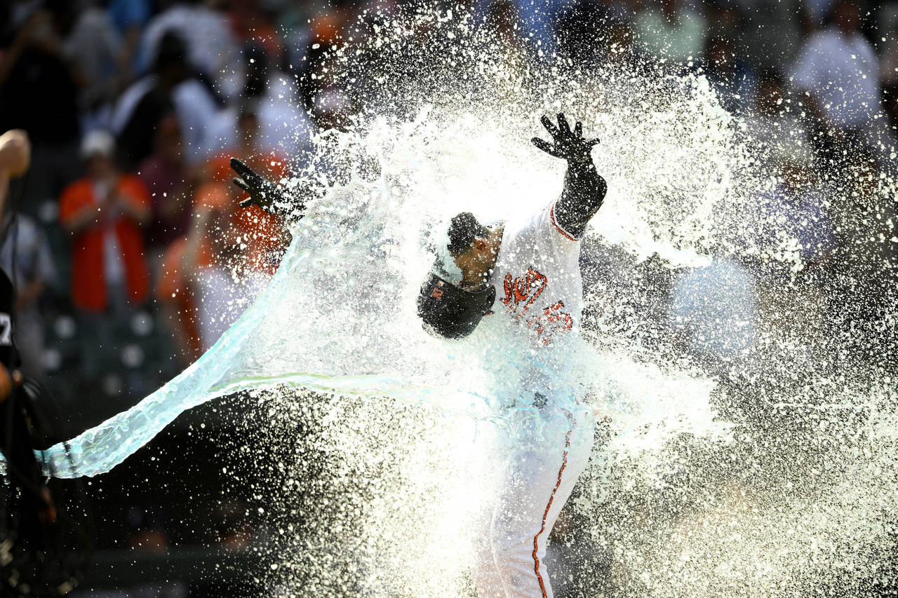 Baltimore Orioles' Anthony Santander is doused as he celebrates heading home after hitting a three-...