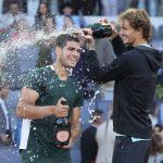 
              Alexander Zverev, of Germany, right, sprays with sparkling wine Carlos Alcaraz, of Spain, at the end of the final match at the Mutua Madrid Open tennis tournament in Madrid, Spain, Sunday, May 8, 2022. Alcaraz won 6-3, 6-1. (AP Photo/Paul White)
            