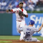 
              Philadelphia Phillies second baseman Jean Segura throws to first after forcing out Los Angeles Dodgers' Will Smith during the third inning of a baseball game, Friday, May 20, 2022, in Philadelphia. Chris Taylor was out at first. (AP Photo/Chris Szagola)
            