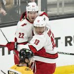 
              Carolina Hurricanes' Brett Pesce (22) celebrates his goal with Hurricanes' Max Domi (13) as Boston Bruins' Matt Grzelcyk, below, skates away in the first period of Game 4 of an NHL hockey Stanley Cup first-round playoff series, Sunday, May 8, 2022, in Boston. (AP Photo/Steven Senne)
            