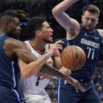 
              Phoenix Suns guard Devin Booker (1) is fouled by Dallas Mavericks forward Reggie Bullock (25) as guard Luka Doncic (77) looks on during the first half of Game 6 of an NBA basketball second-round playoff series Thursday, May 12, 2022, in Dallas. (AP Photo/Tony Gutierrez)
            