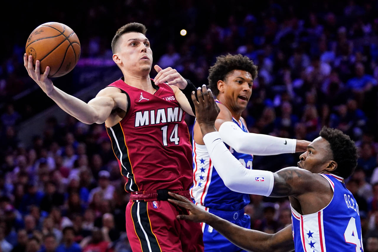 Miami Heat's Tyler Herro (14) goes up for a shot against Philadelphia 76ers' Matisse Thybulle, cent...