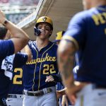 
              Milwaukee Brewers' Christian Yelich high-fives teammates in the dugout after scoring a run during the ninth inning of a baseball game against the Cincinnati Reds in Cincinnati, Wednesday, May 11, 2022. The Reds won 14-11. (AP Photo/Aaron Doster)
            